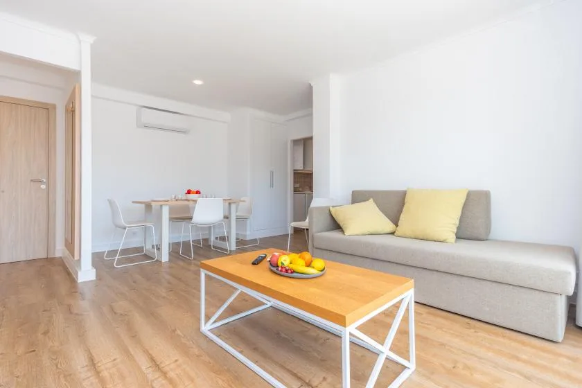 A bright living area with seating, a coffee table, and a dining table.