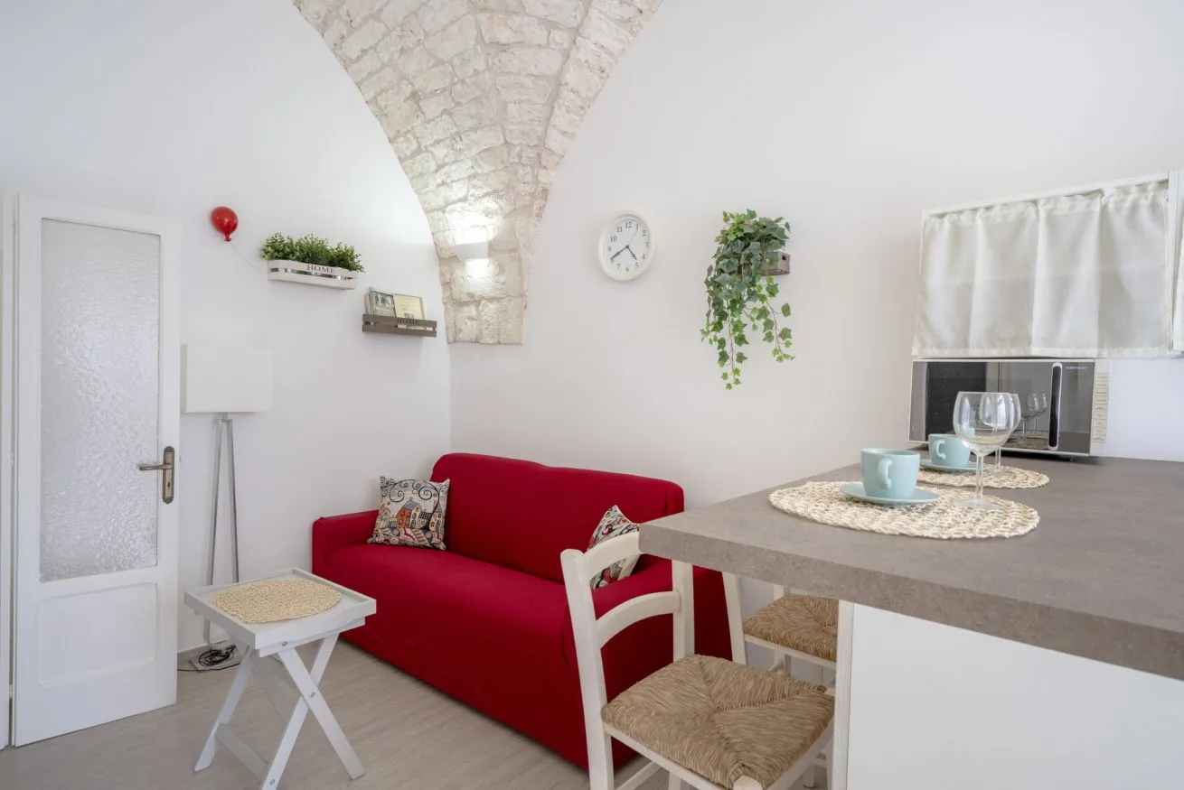 A bright living area with red seating and a stone vaulted ceiling.