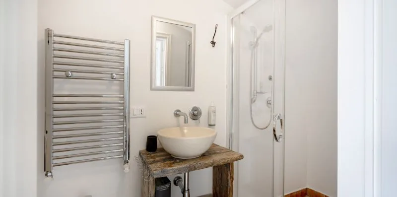 A bathroom with a vessel sink and glass shower enclosure.