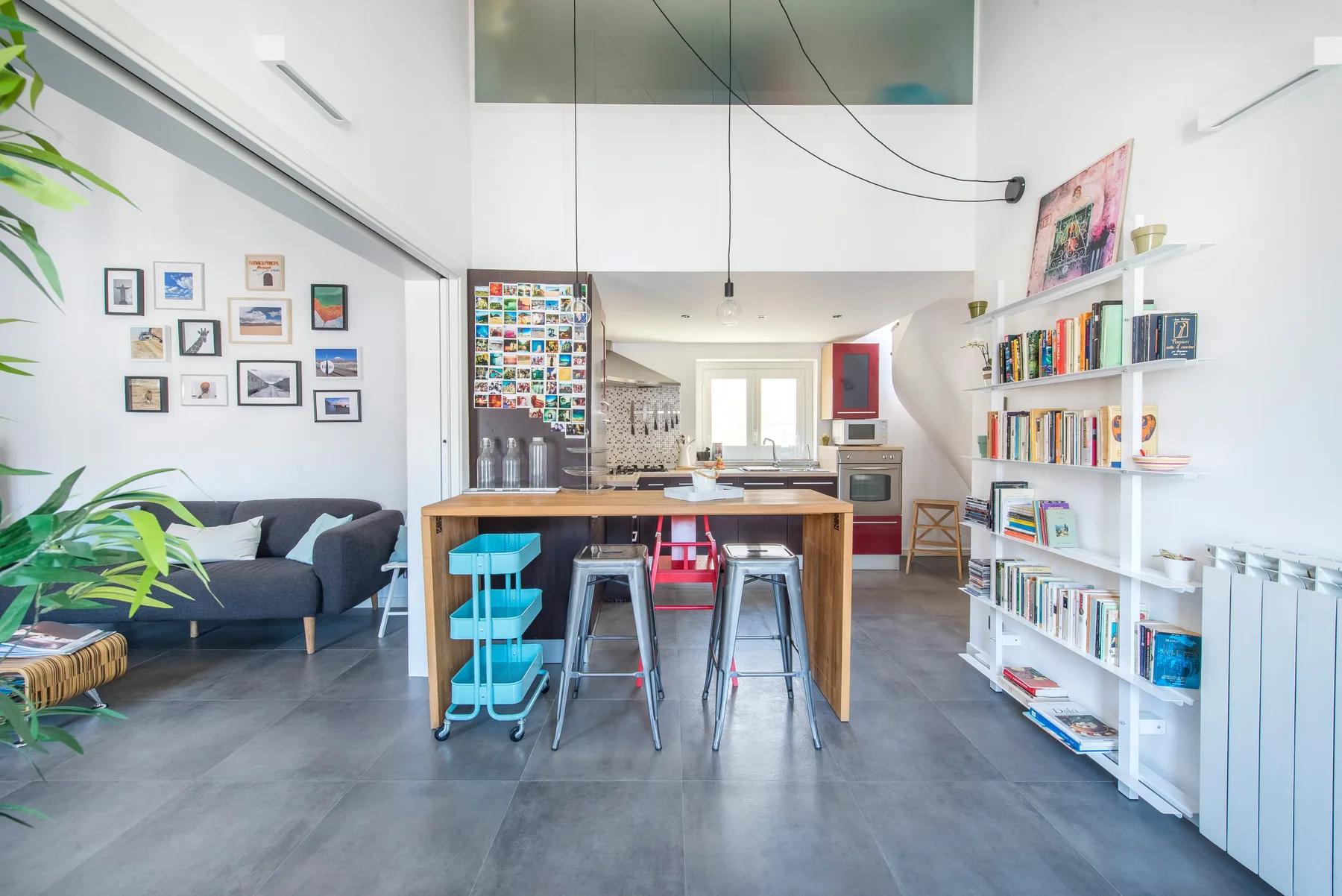 Una luminosa sala de estar y cocina de concepto abierto, con mesa y estanterías.