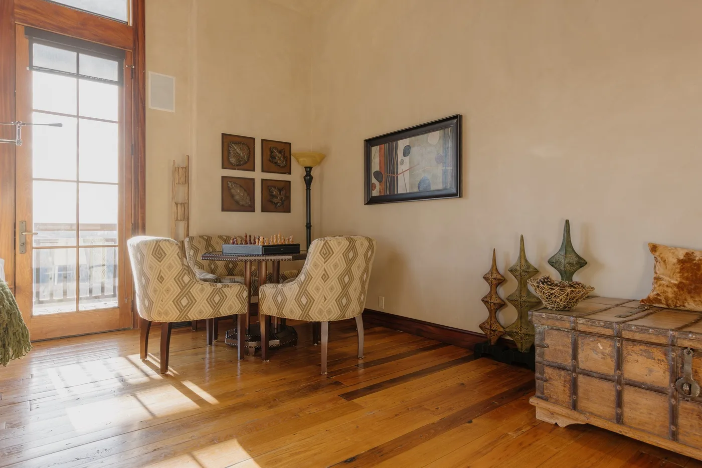 A dining area with patterned seating, a table, and a tall glazed door.