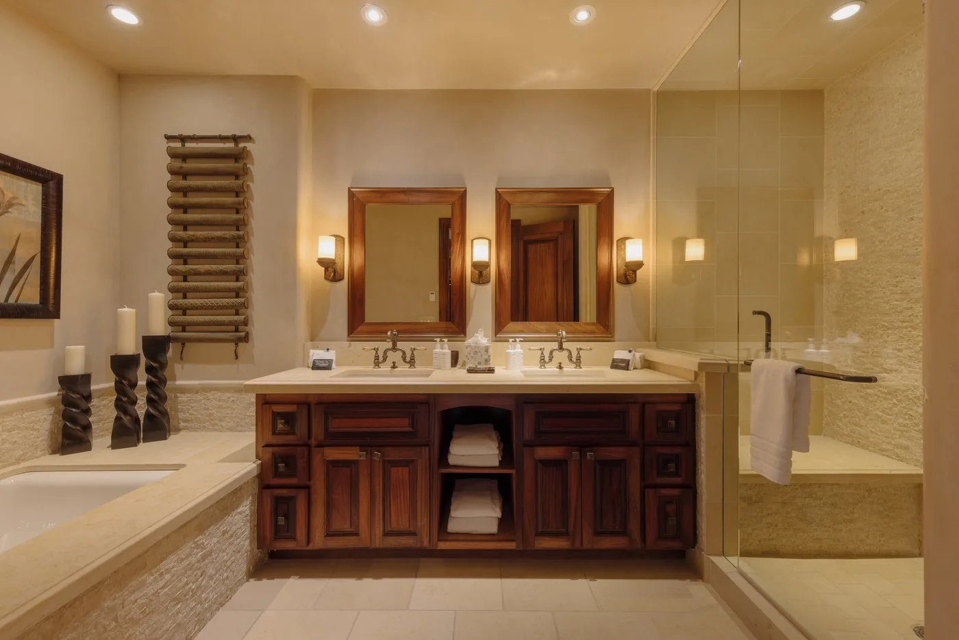 A bathroom vanity with twin sinks and mirrors, beside a glass-enclosed shower.