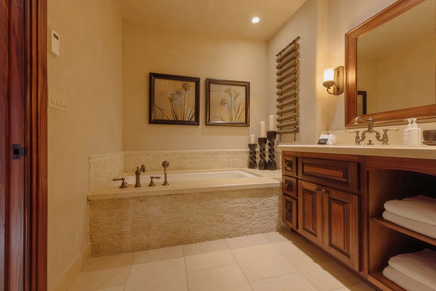 A bathroom with a bathtub and a wooden vanity beneath a mirror.