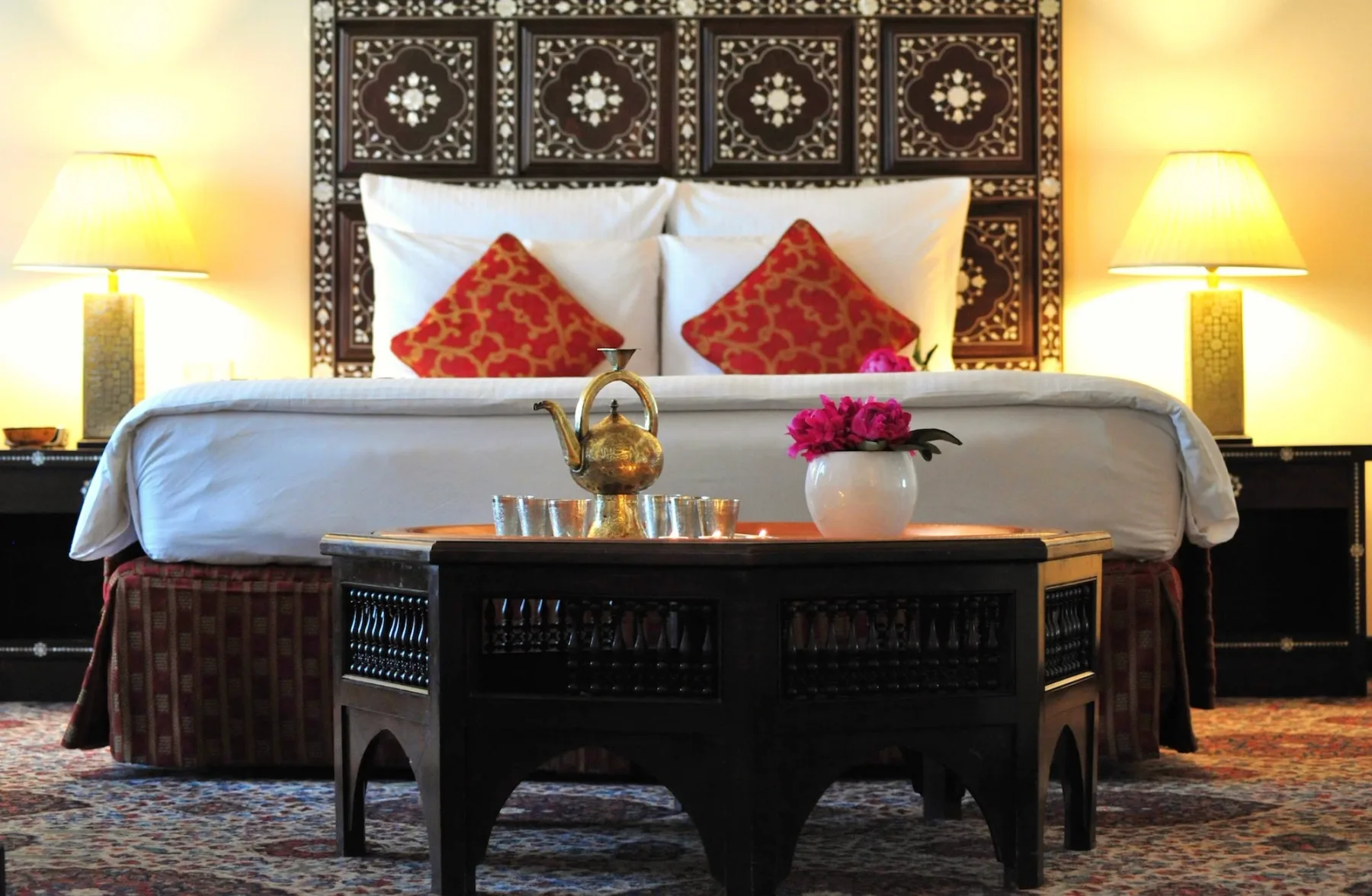 Cama de la suite oriental con cabecero con incrustaciones de nácar y juego de té de latón