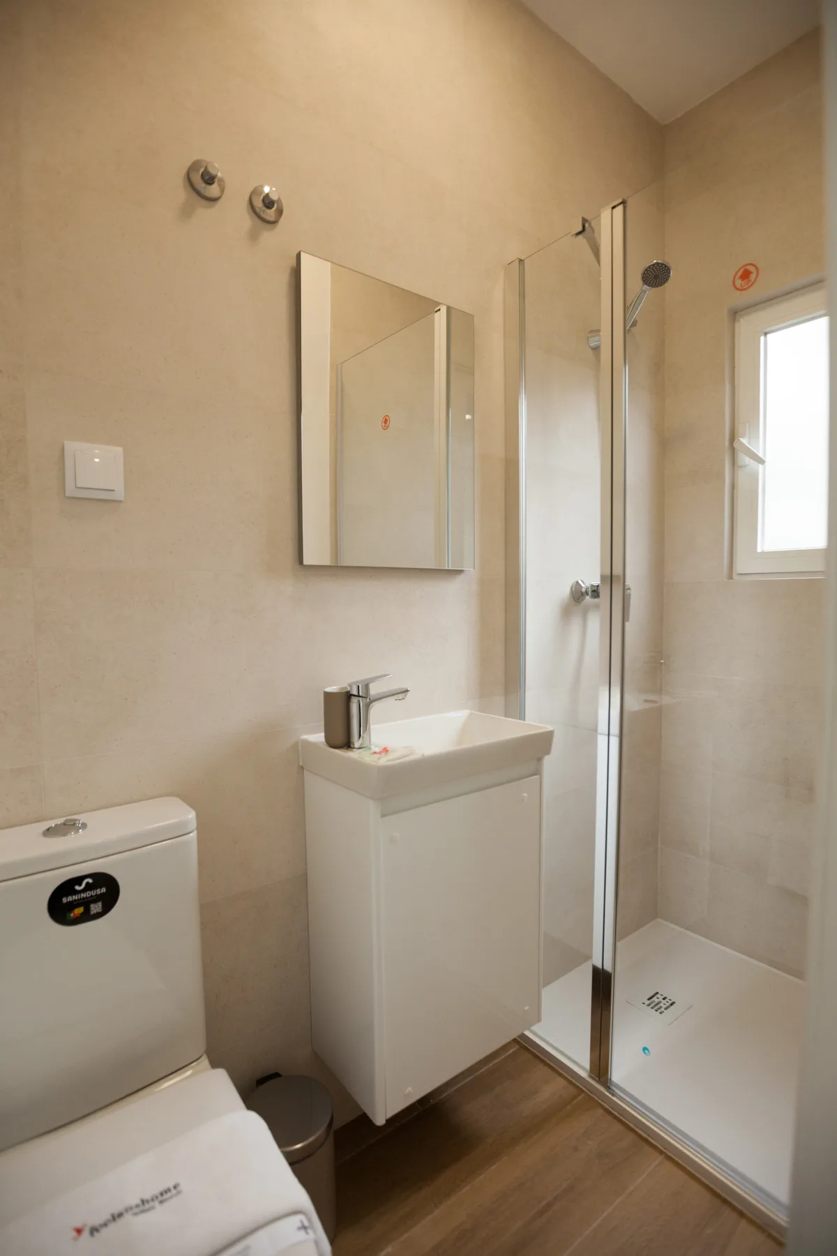 A bathroom with a sink, toilet, and glass shower.