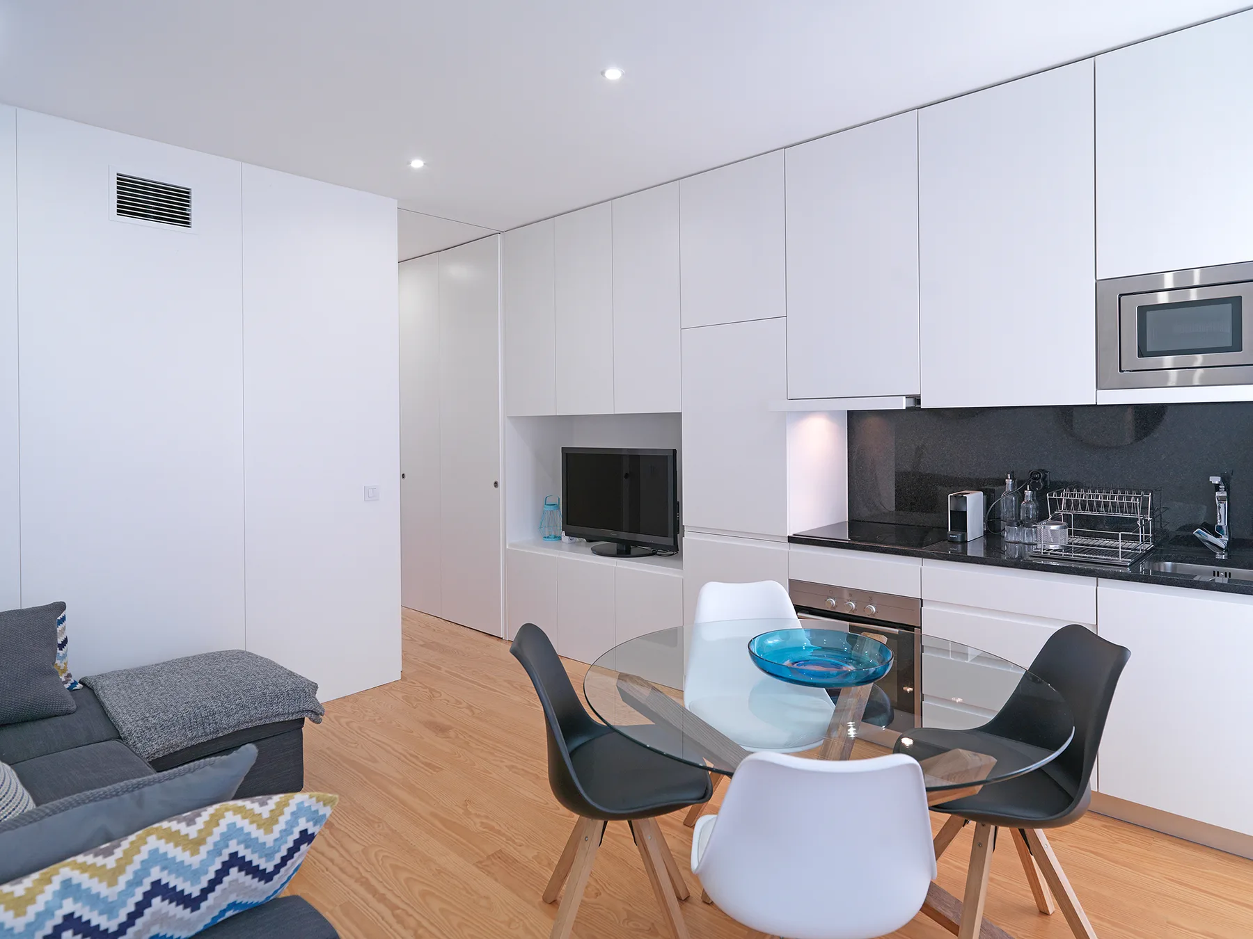 Una luminosa sala de estar y comedor de planta abierta junto a una cocina compacta.