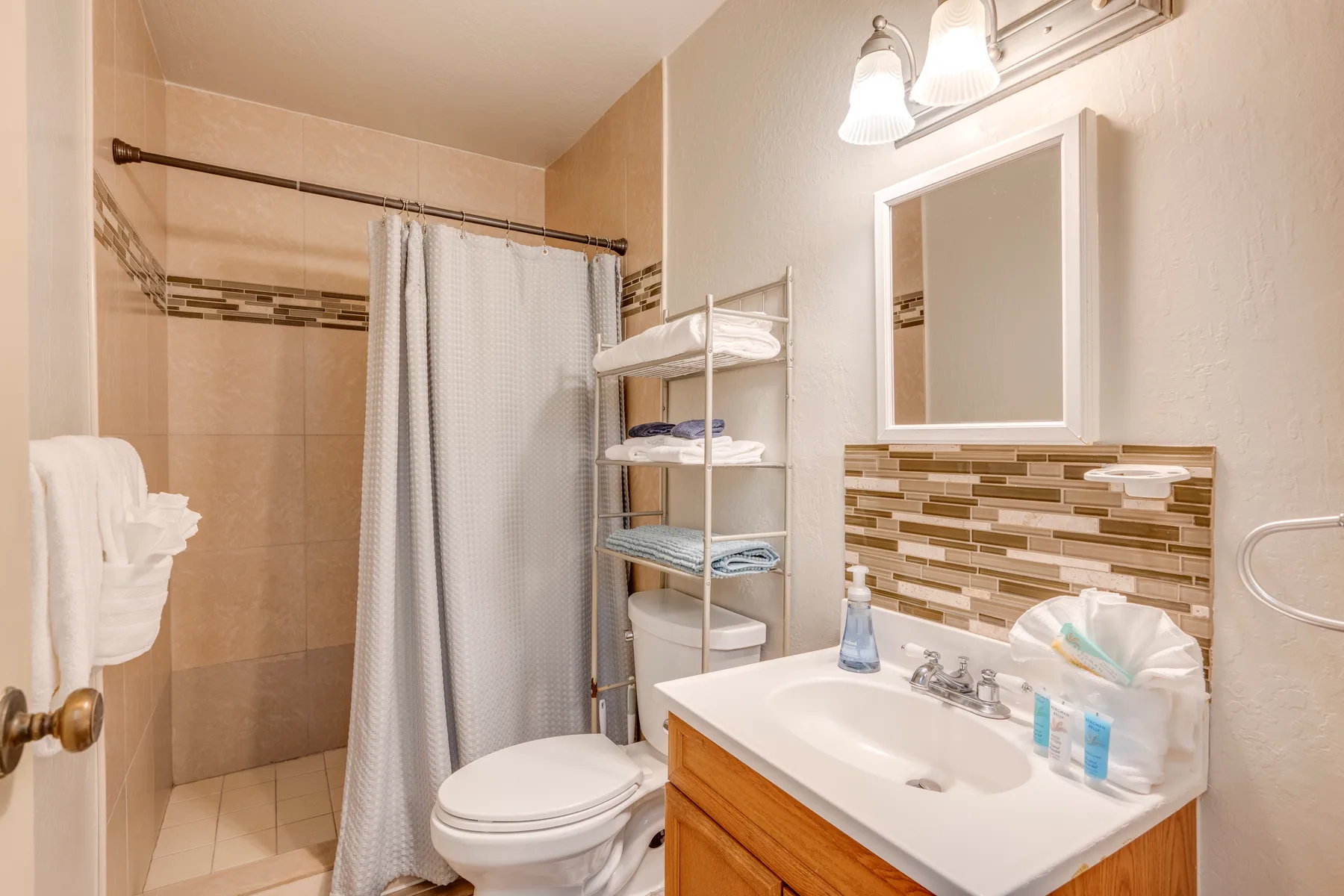 Un baño con cortina de ducha, inodoro y lavabo.