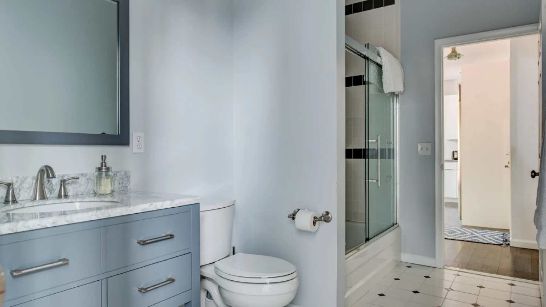 A bathroom with a vanity, toilet, and glass shower.