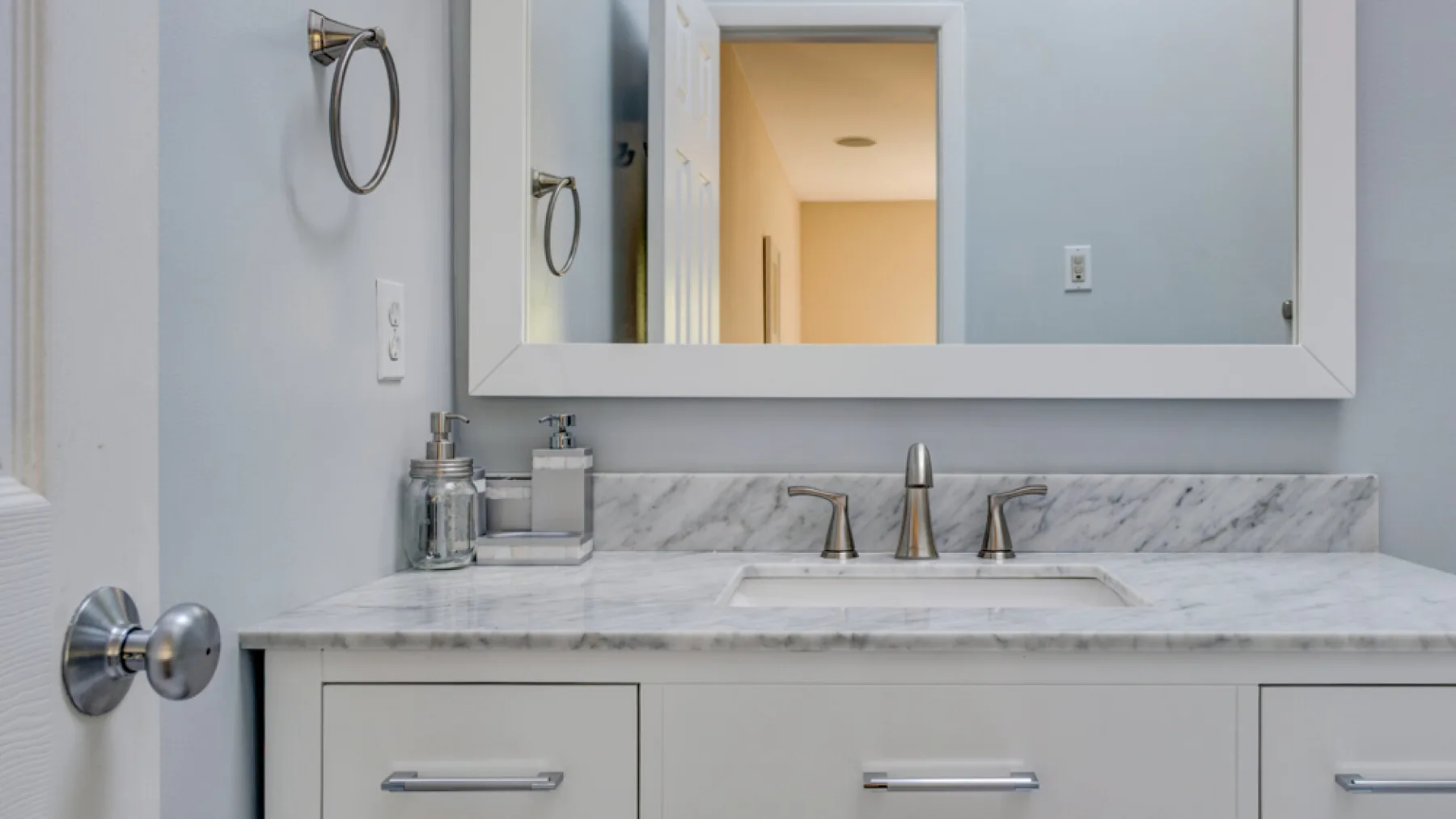 A bathroom vanity with a sink and mirrored cabinet.