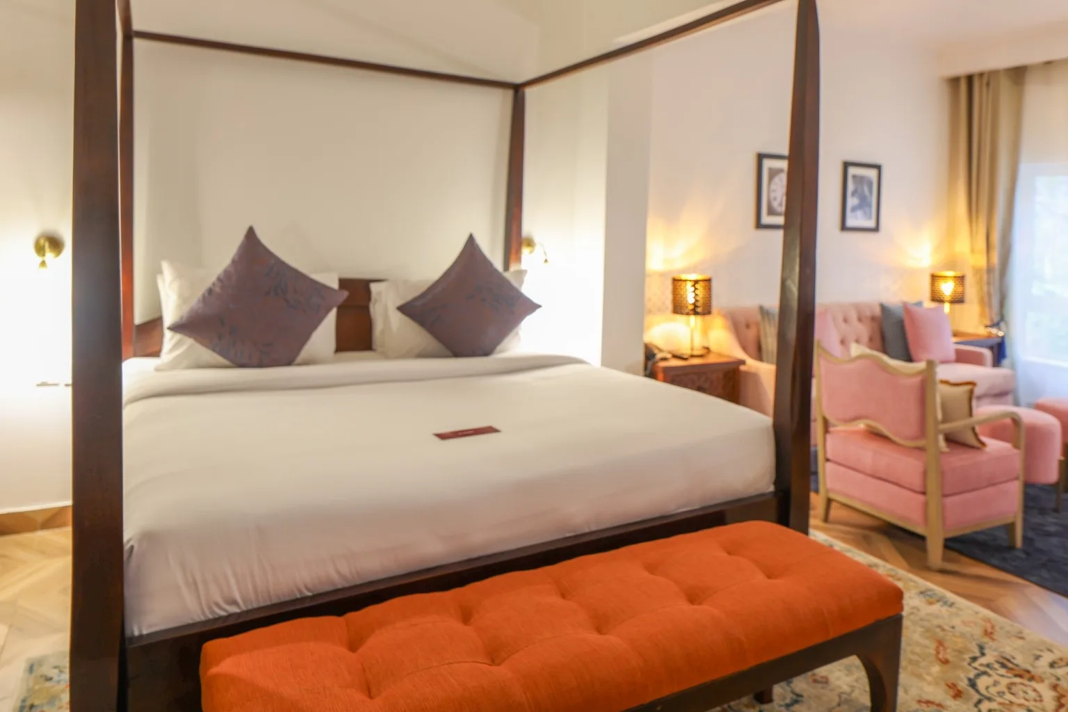 Una cama con dosel en una suite Executive, con la sala de estar independiente visible al fondo.