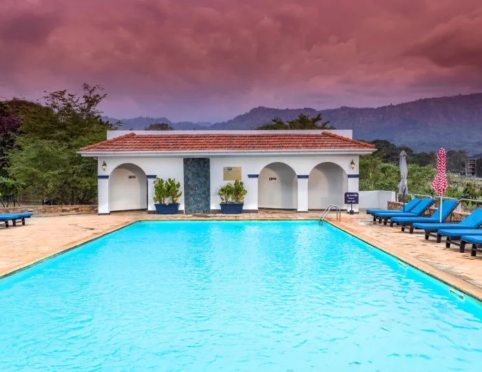 La piscina al aire libre y las tumbonas, con las estribaciones del monte Elgon al fondo.