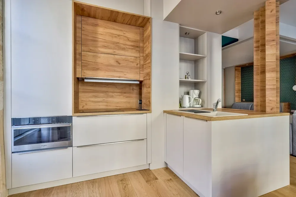 Una cocina moderna con gabinetes de madera clara y una isla central.