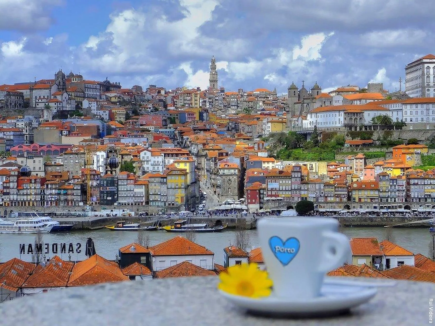 View across the river toward Porto’s hillside buildings, with a coffee cup in the foreground.