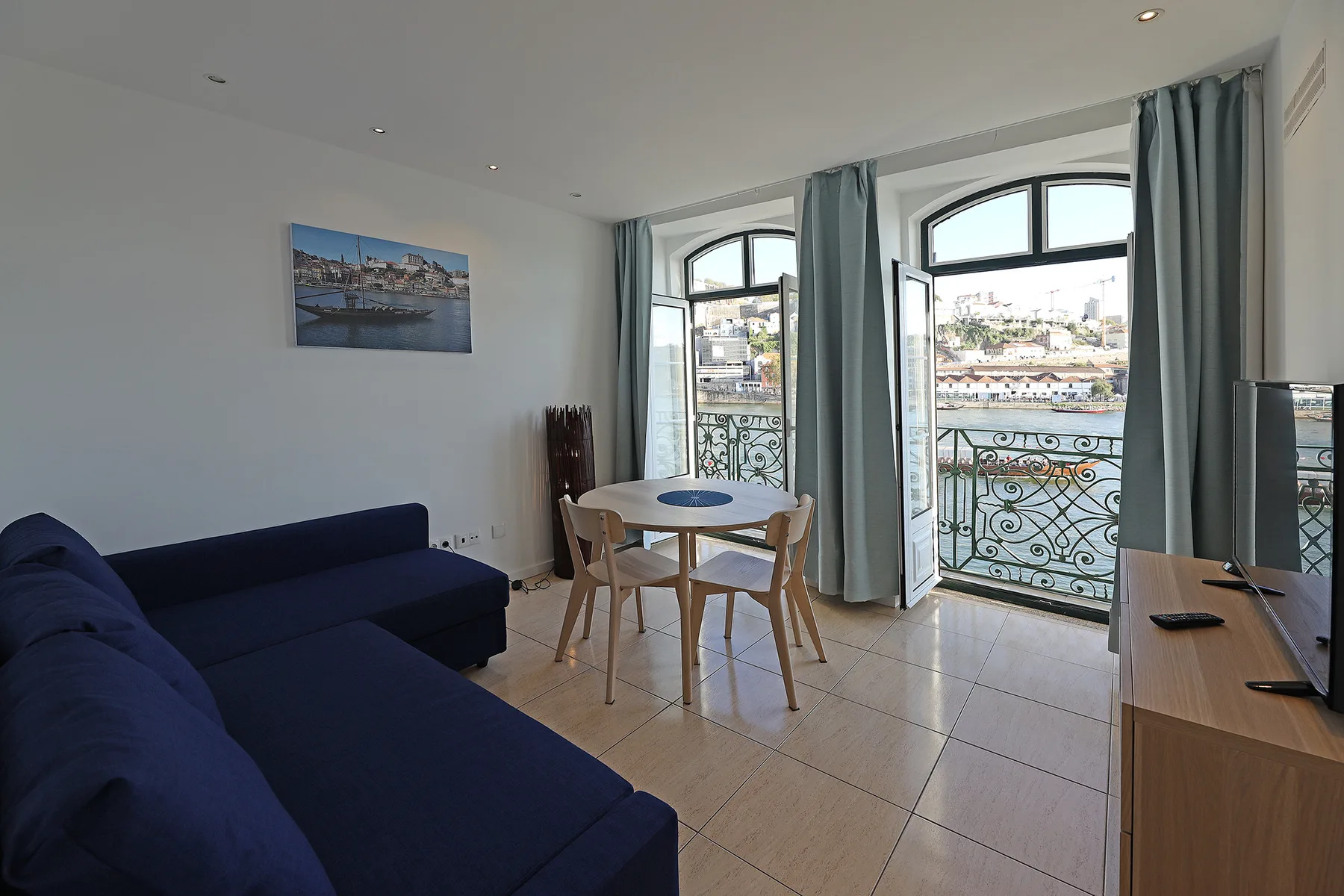 Living room with a dining table beside large windows overlooking the river.