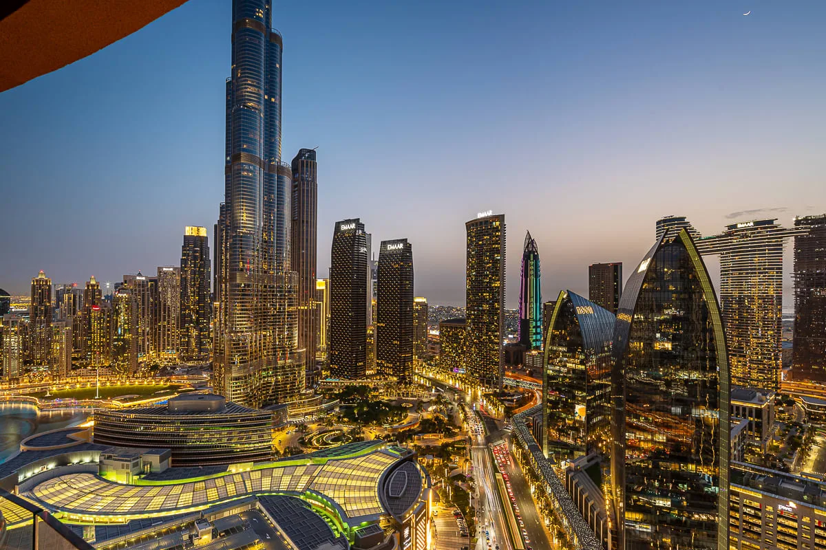 El Burj Khalifa se eleva sobre un horizonte urbano iluminado al anochecer.