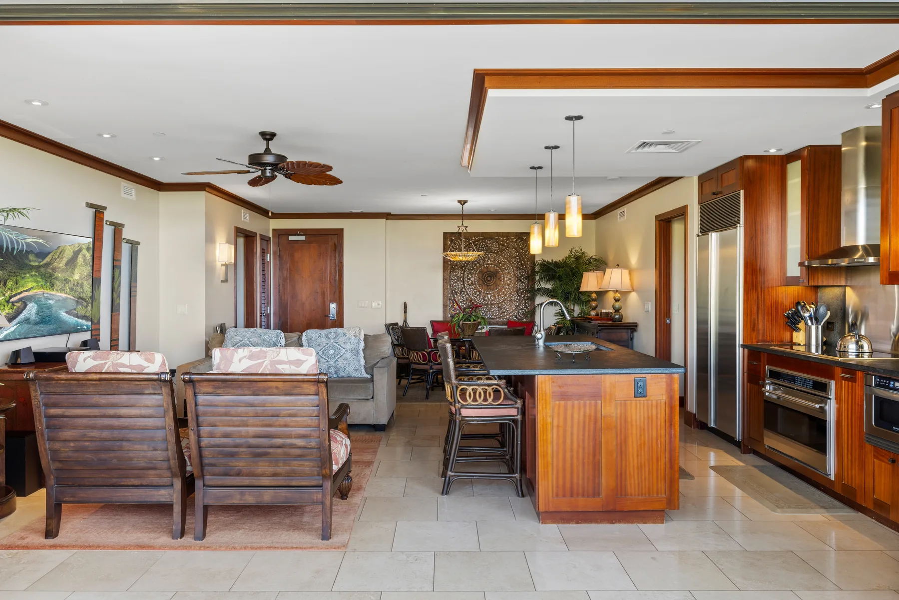 Sala de estar y cocina abiertas con una isla central y asientos.