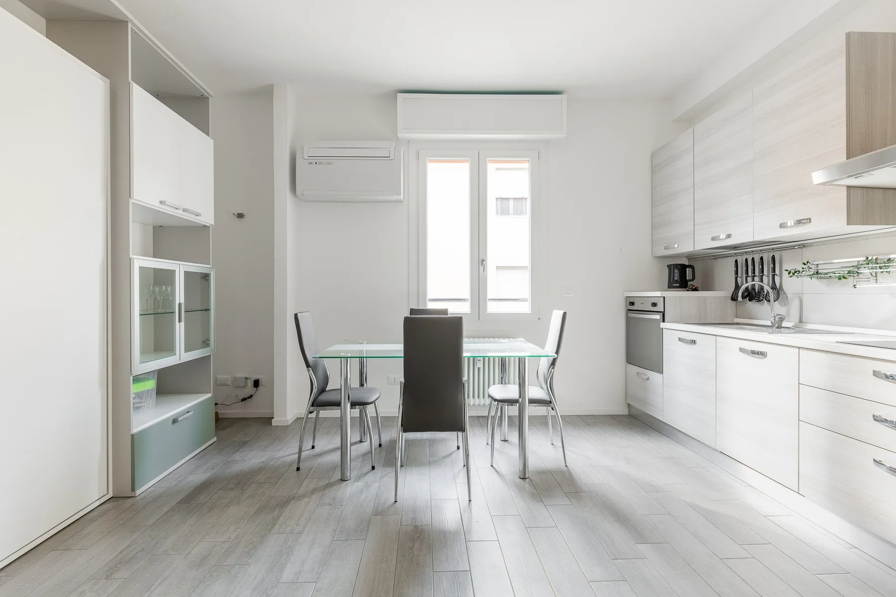 A bright kitchen and dining area with a table beside the windows.