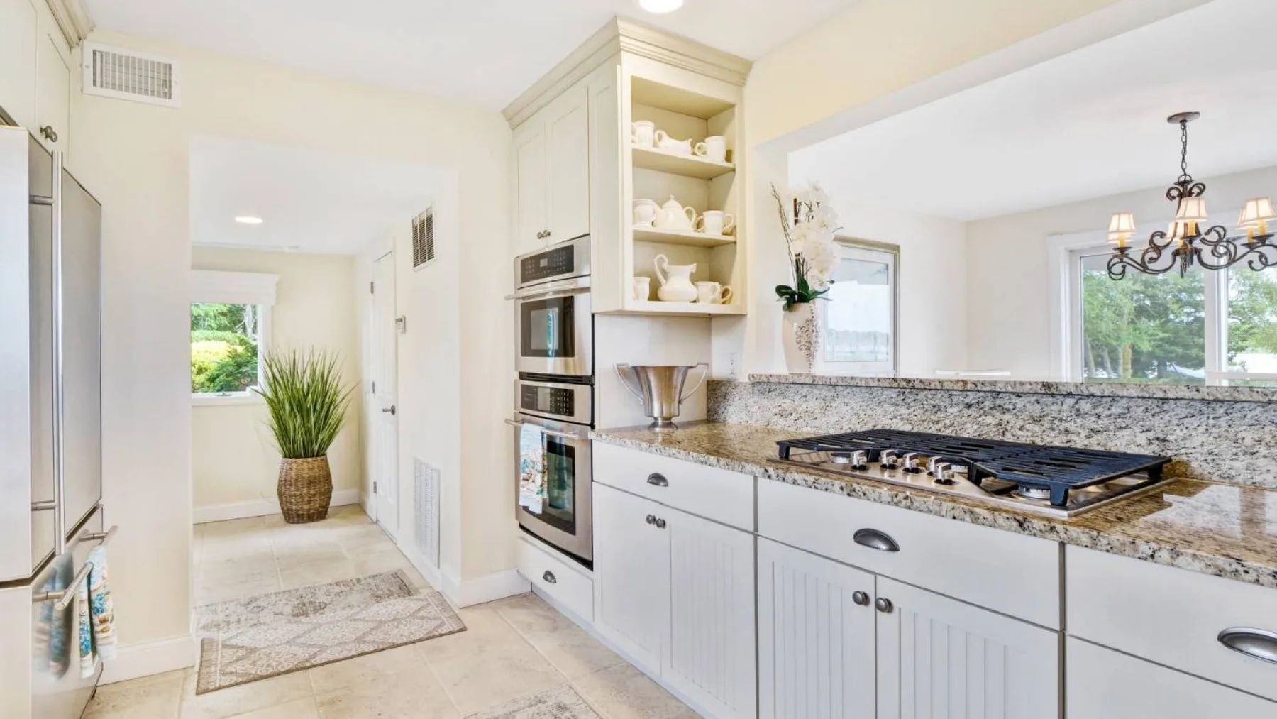 Una cocina luminosa con gabinetes blancos y una amplia encimera.