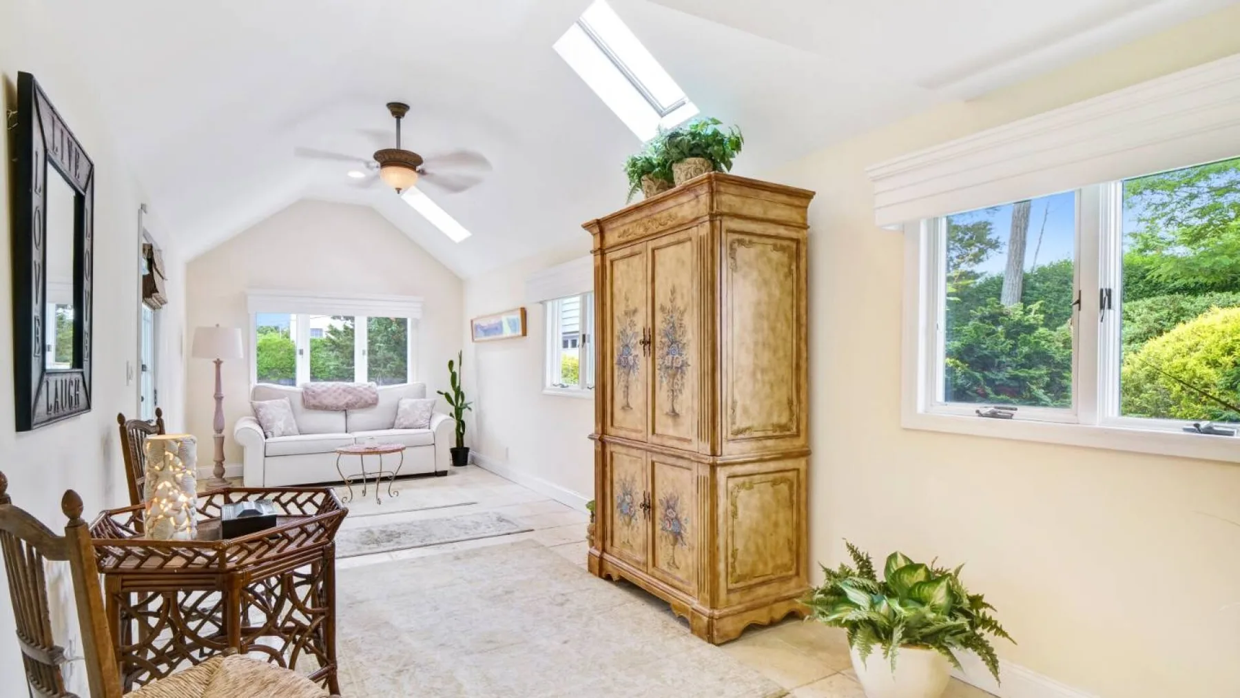 A bright living room with seating beneath a sloped ceiling and skylight.