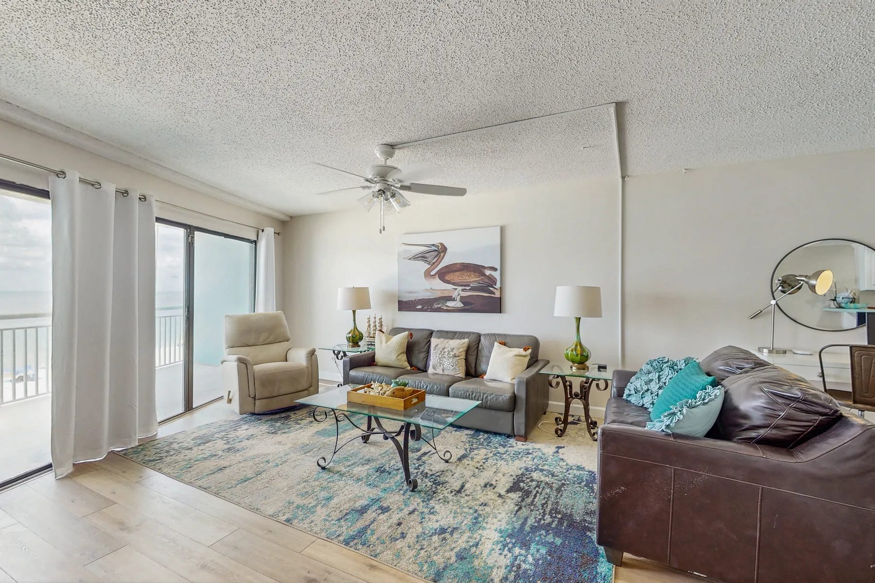 A bright living room with seating arranged around a glass coffee table.