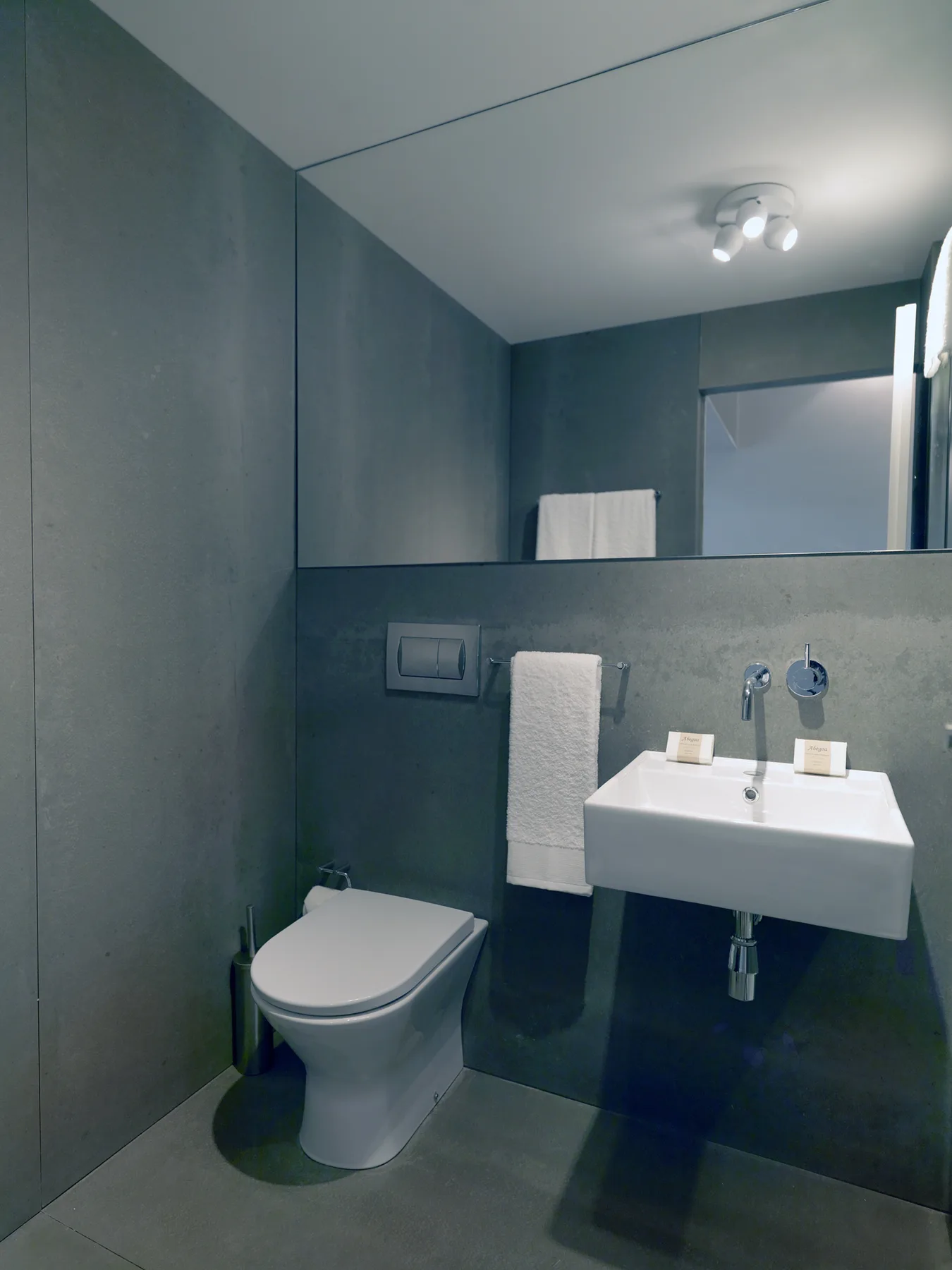 A modern bathroom with a wall-mounted sink and toilet.