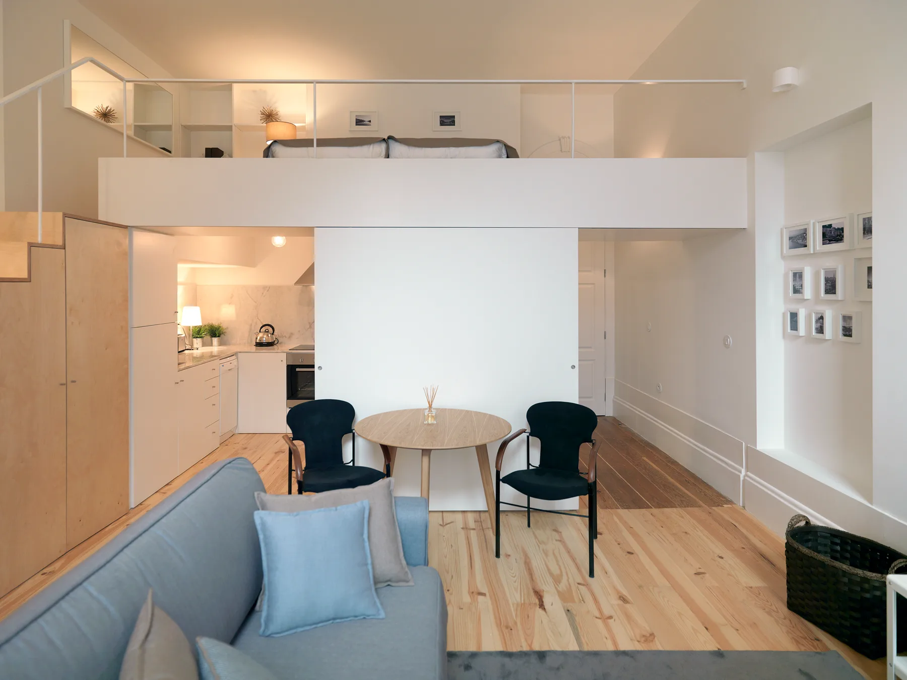 A loft-style living area with seating, a dining table, and a kitchen.
