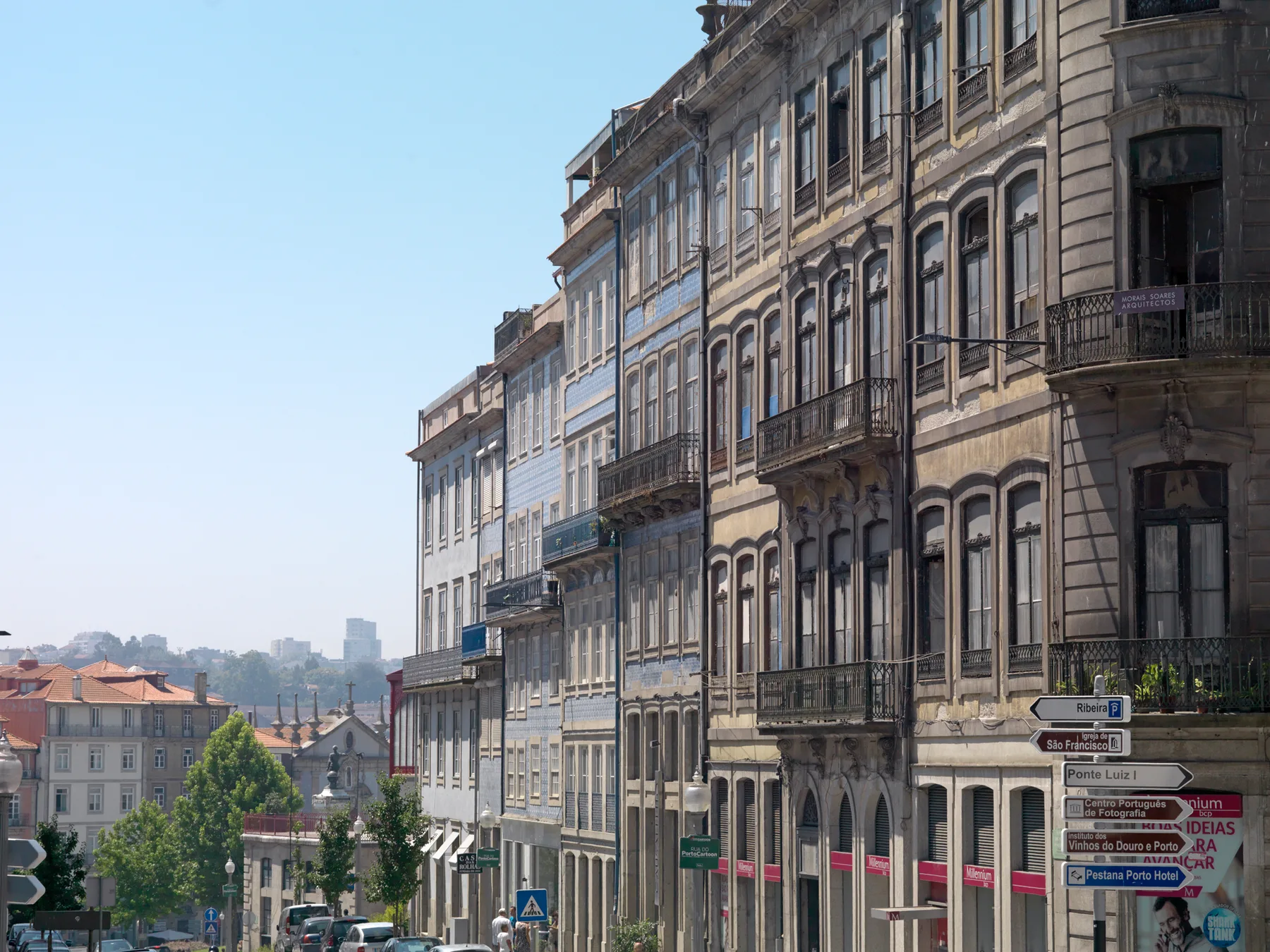A city street lined with tall historic buildings and traffic signs.