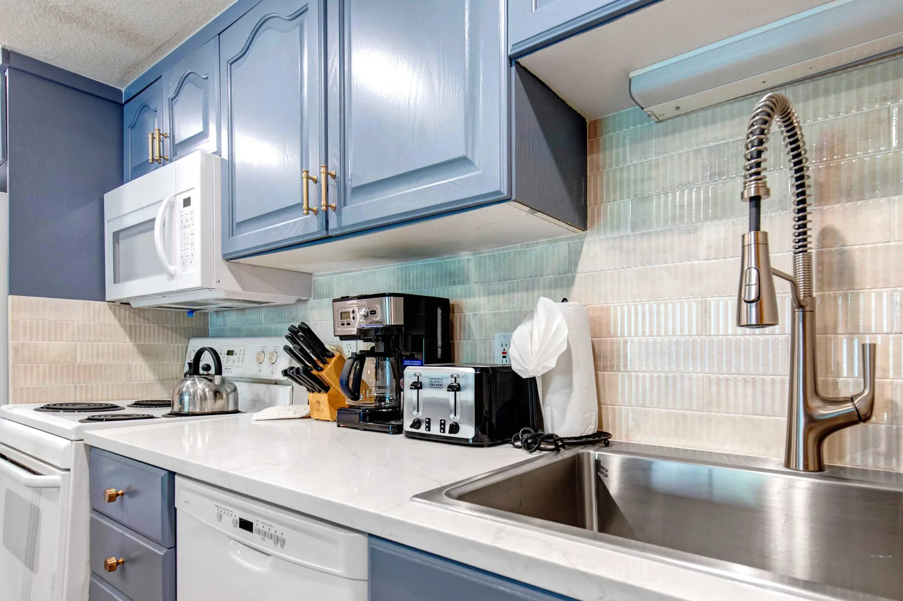 Una cocina con gabinetes azules, una encimera y un fregadero de acero inoxidable.