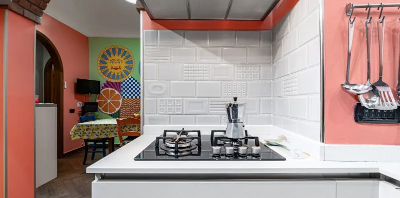 A kitchen with a gas cooktop and tiled backsplash.