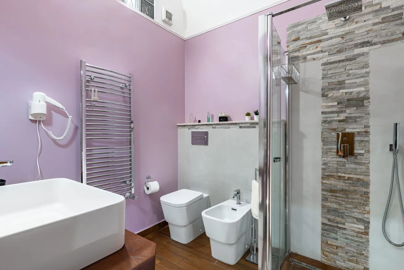 A bathroom with a bathtub, toilet, and glass shower.
