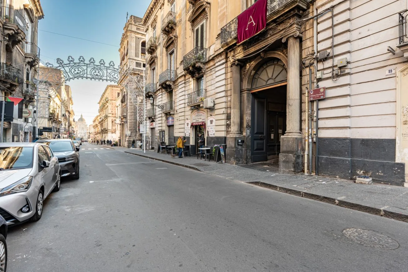 A city street lined with historic buildings and parked cars.