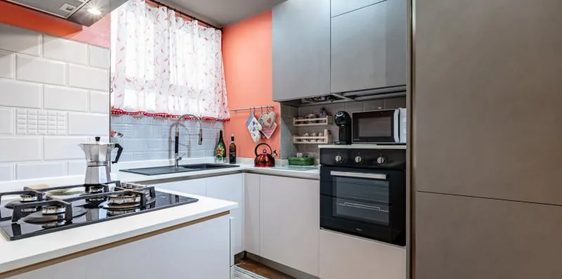 A modern kitchen with a gas cooktop, sink, and built-in oven.
