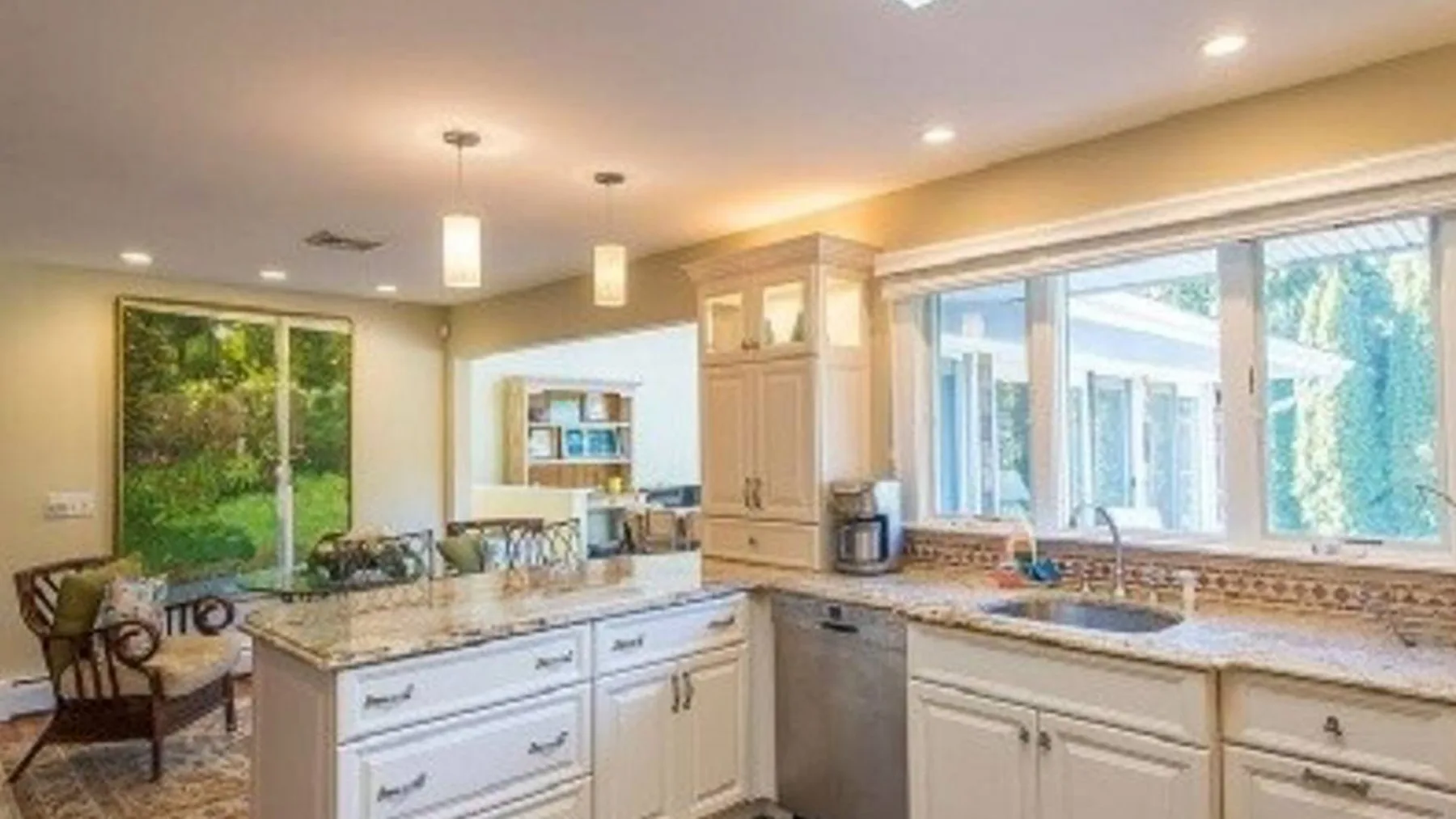Una cocina luminosa con isla central, amplias ventanas y zona de comedor.