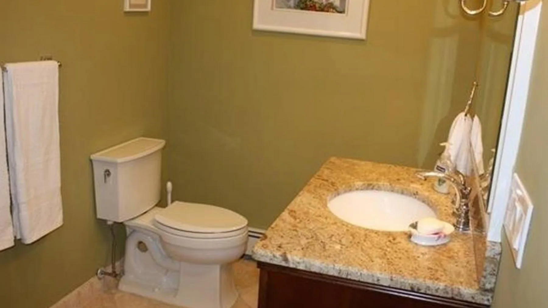 Un baño con un inodoro y un lavabo integrado en una encimera de piedra.