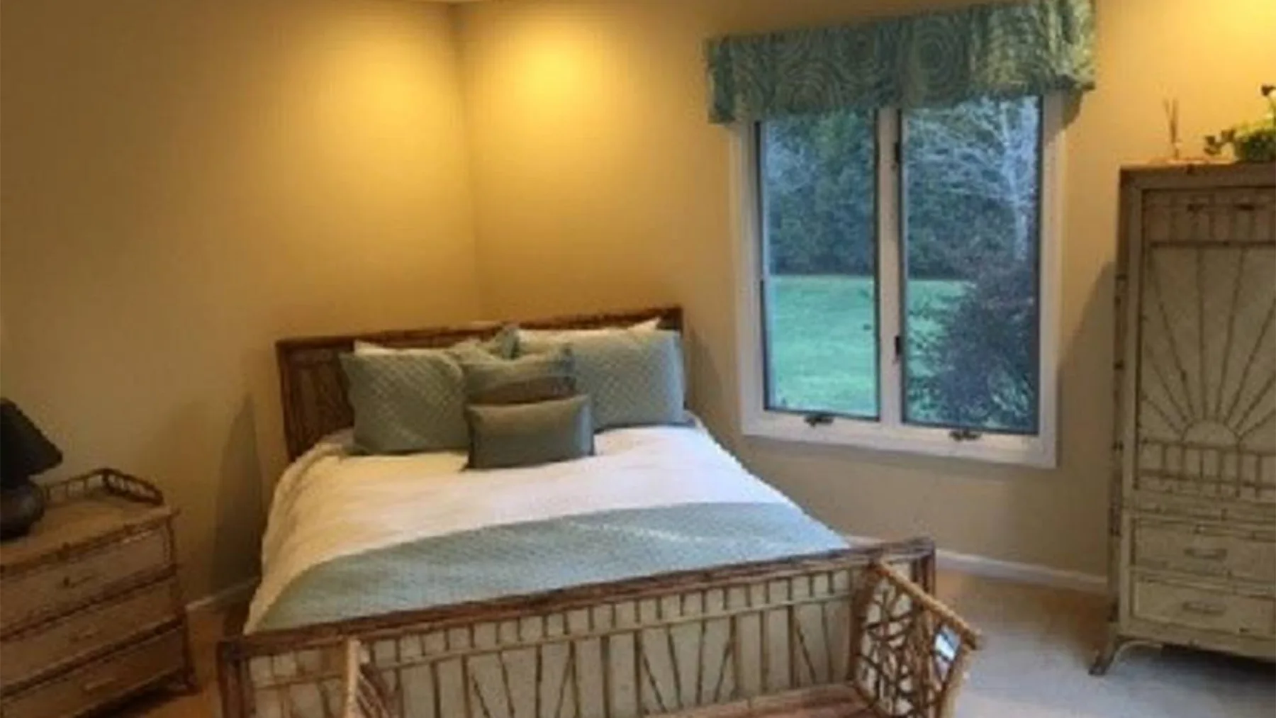 Un dormitorio con una cama, una ventana y una cómoda.