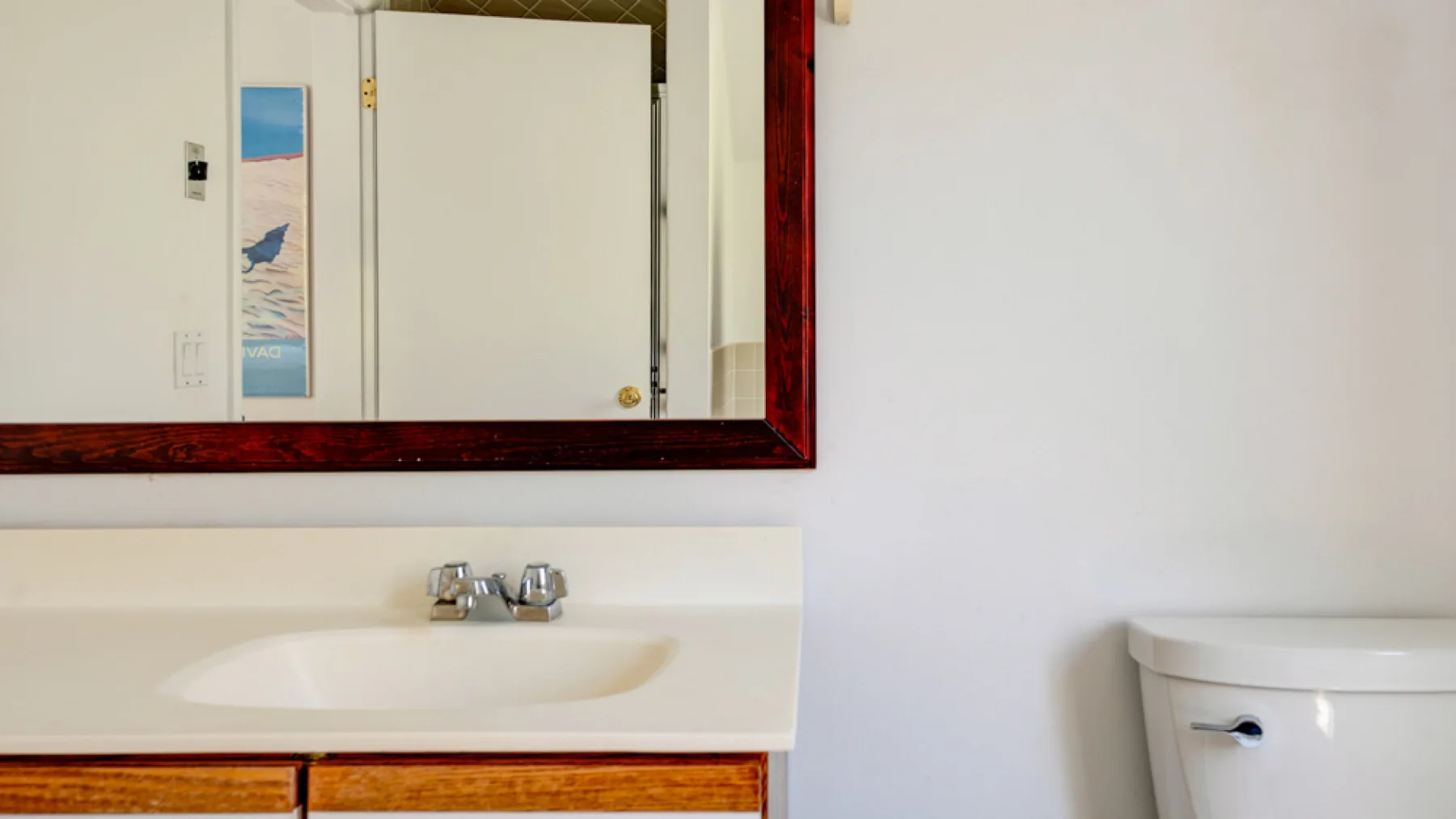 A bathroom vanity with a sink and a toilet beside it.