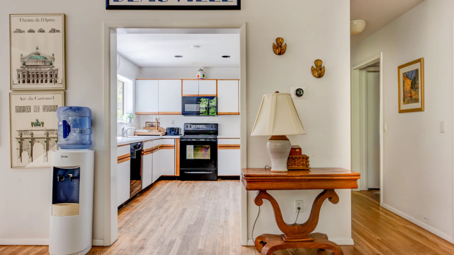 A kitchen opens onto a hallway, with a console table beside the doorway.