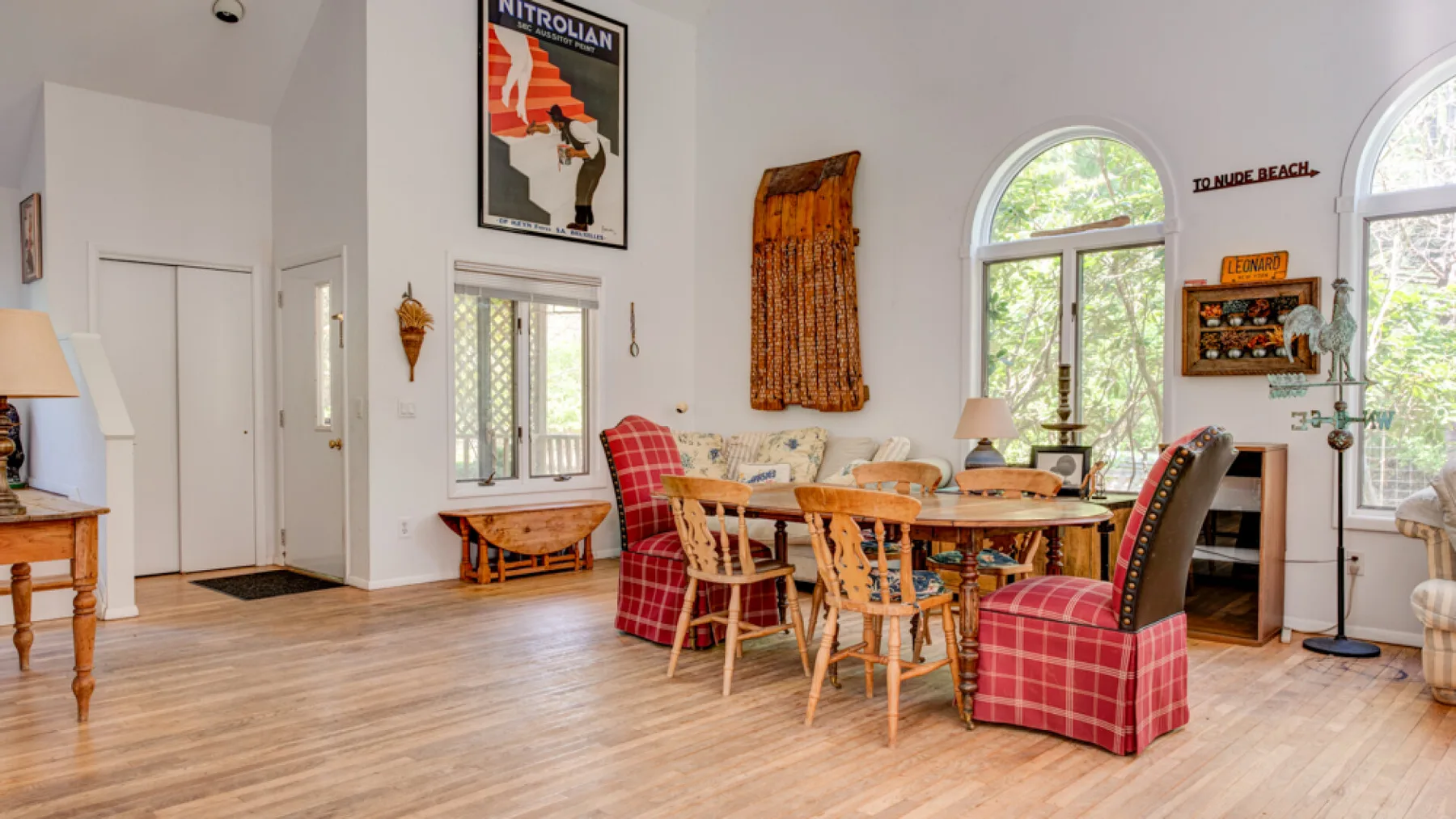 A bright dining room with a wooden table and red plaid seating.
