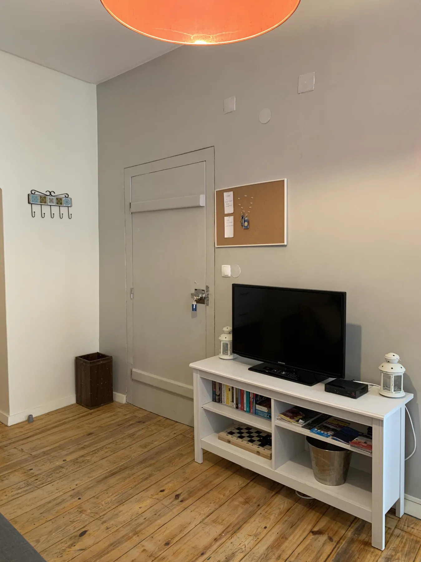 A living area with a television on a low shelf beside a closed door.