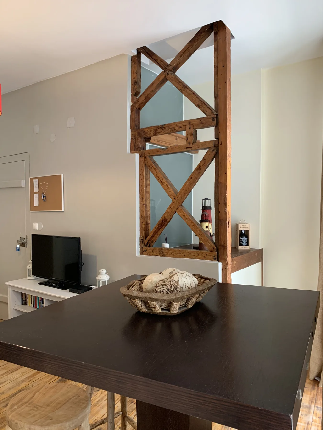 A dining area with a dark table and a timber-framed partition.
