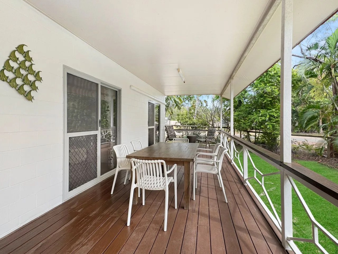 A covered outdoor dining area with a long table and seating.