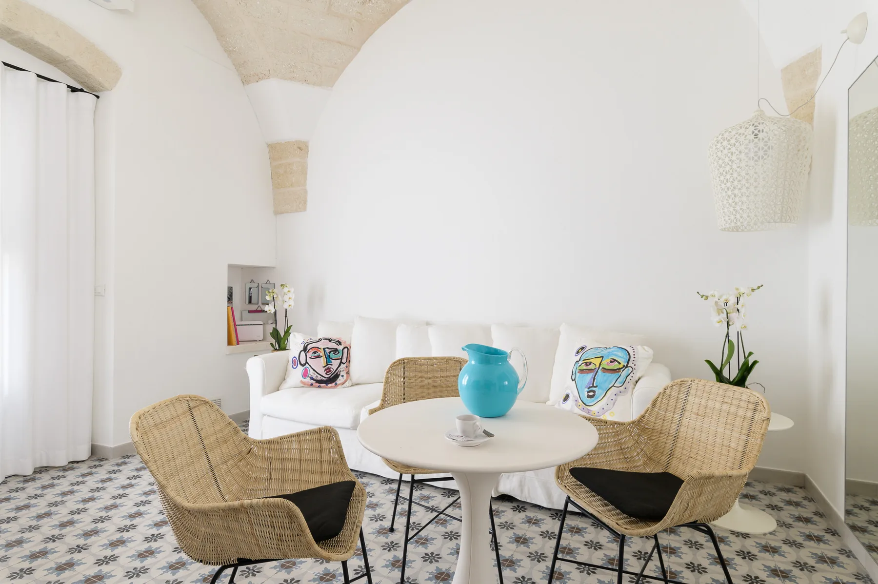 Una luminosa sala de estar con asientos tejidos alrededor de una mesa pequeña.