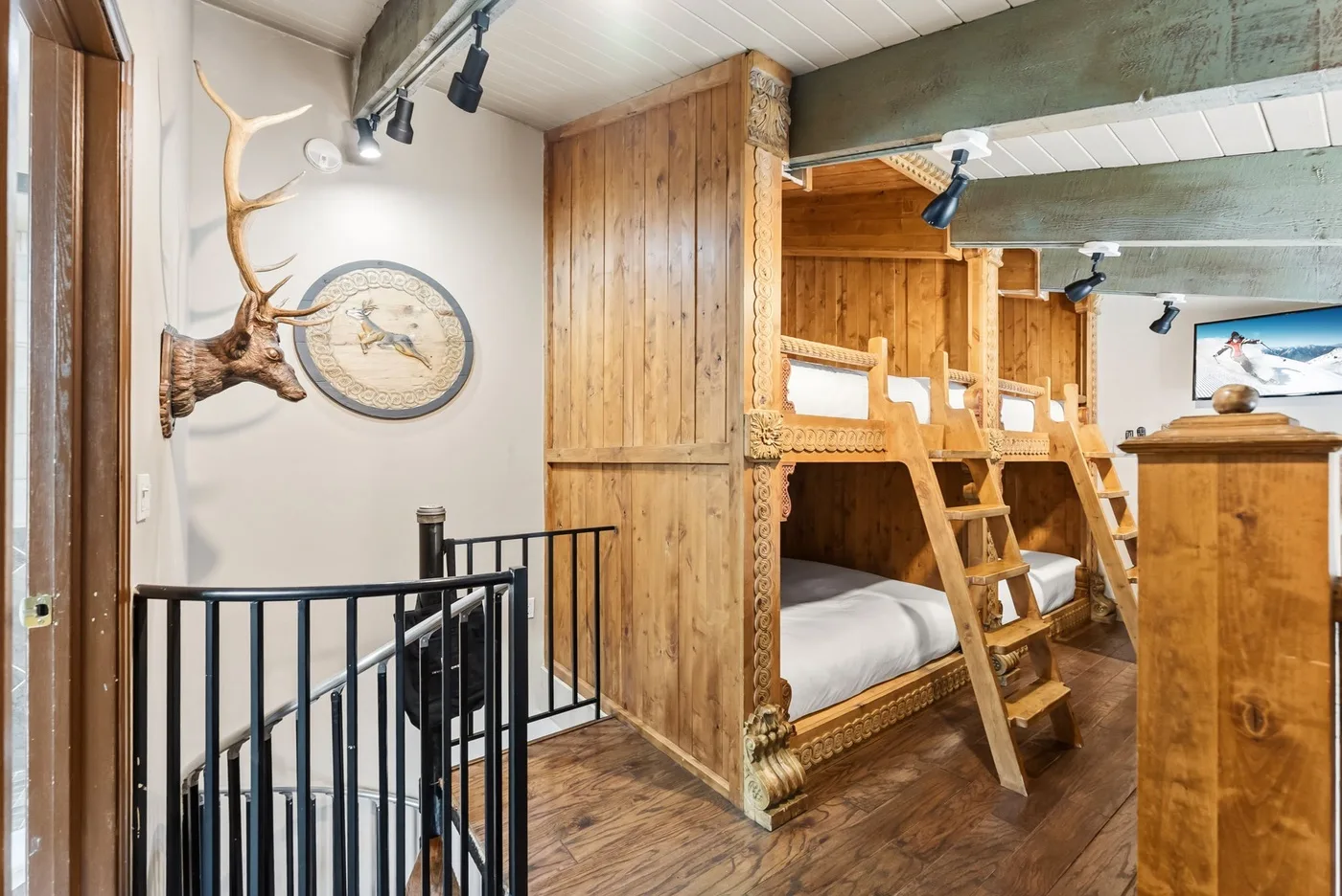 A wood-paneled room with built-in bunk beds and a black railing.