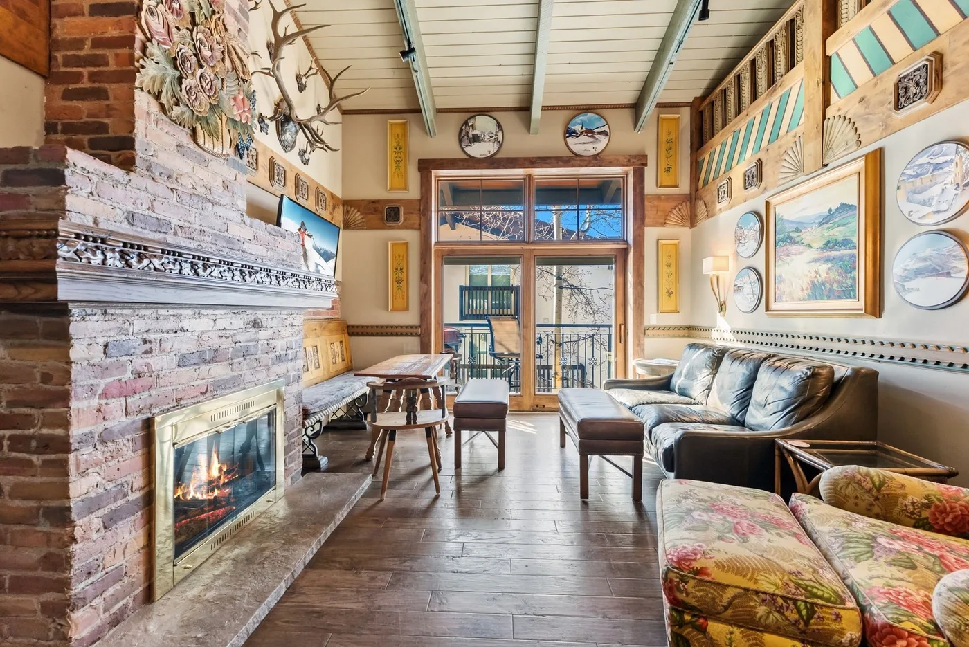 A living room with a brick fireplace, seating, and a coffee table.