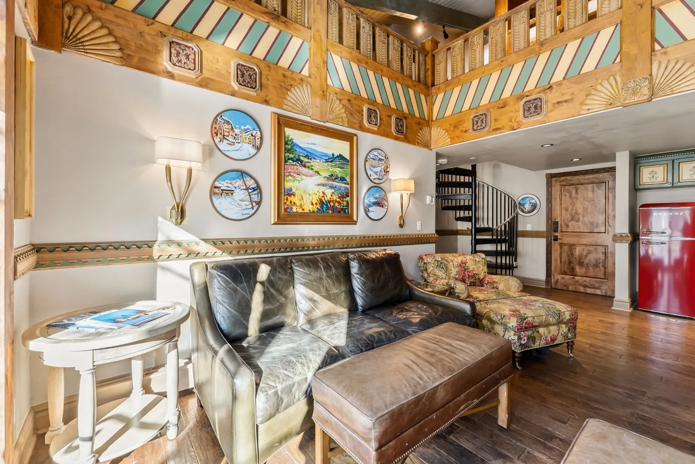A living room with leather seating, a colorful wall display, and wood trim.