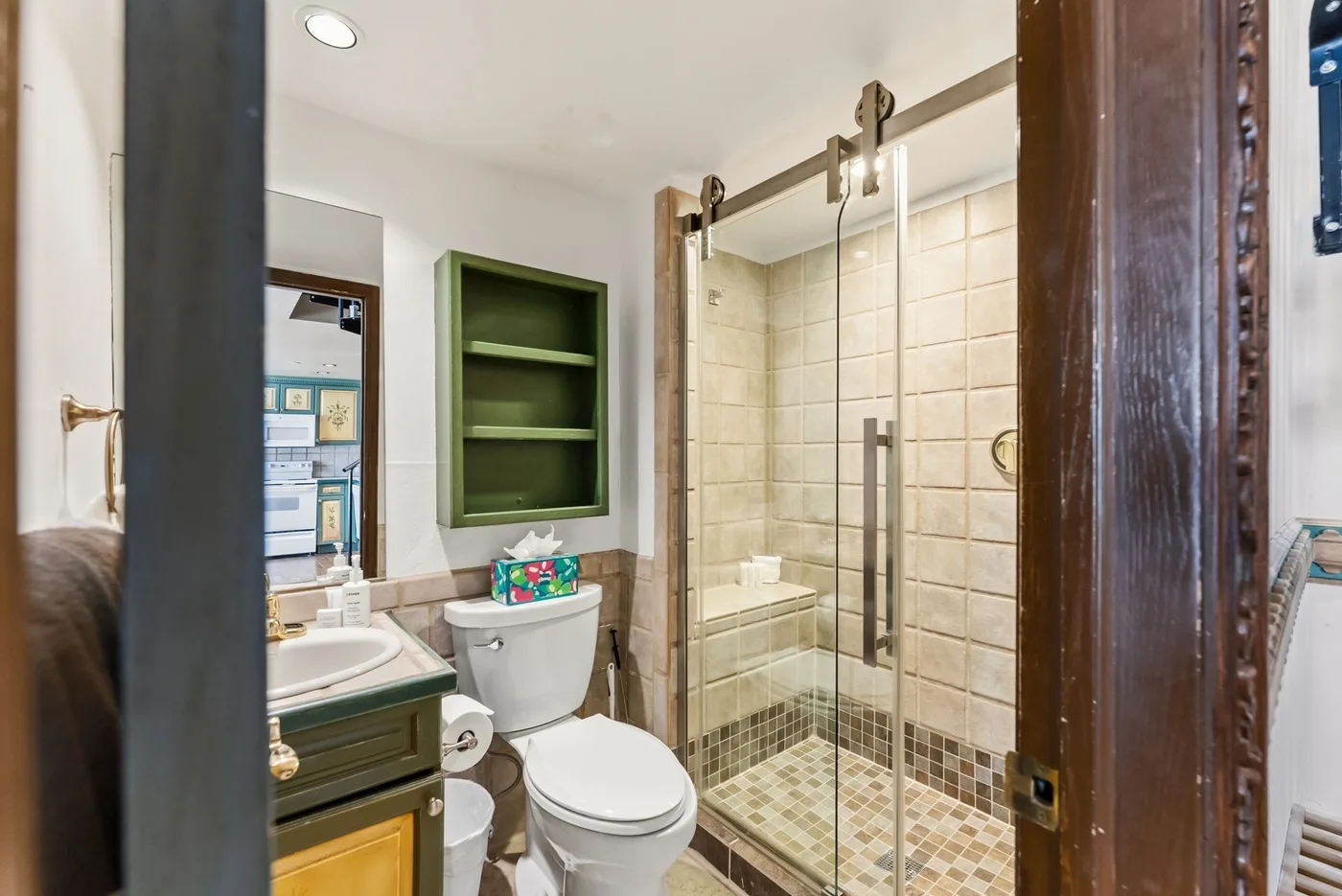 A bathroom with a toilet, sink, and glass shower.