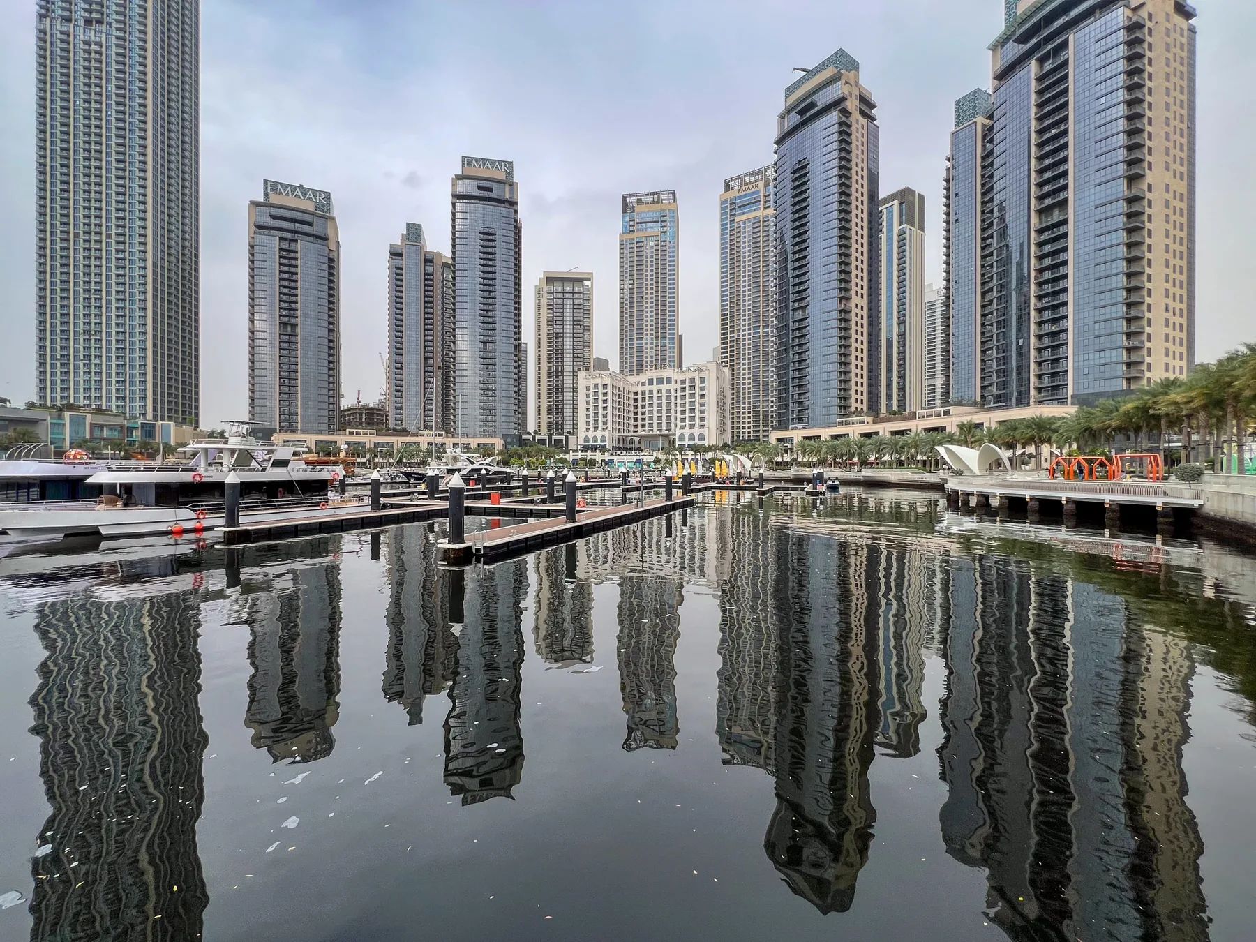 Una marina refleja una hilera de edificios modernos y altos.
