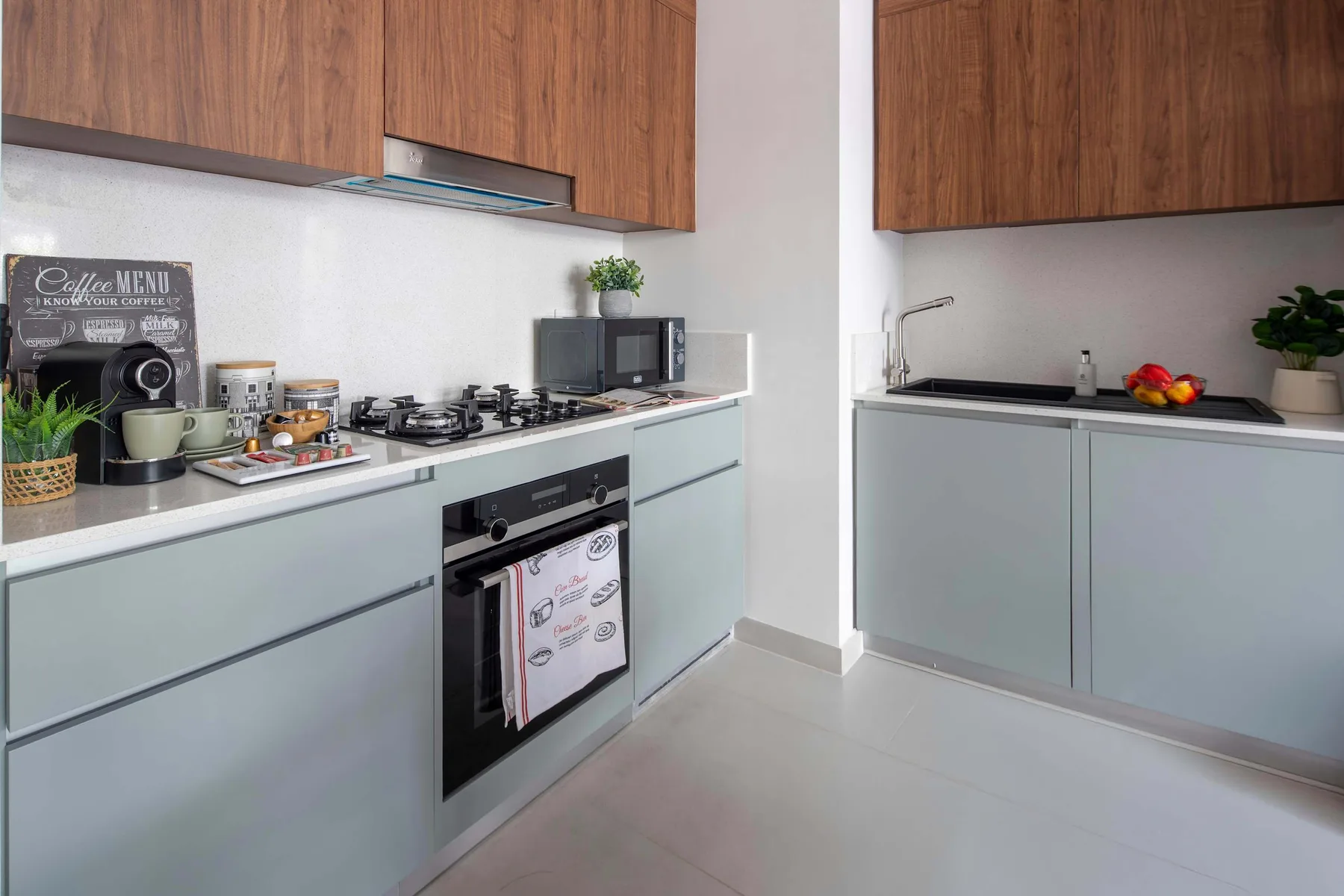 Una cocina moderna con gabinetes de madera, encimeras claras y una estufa de gas.