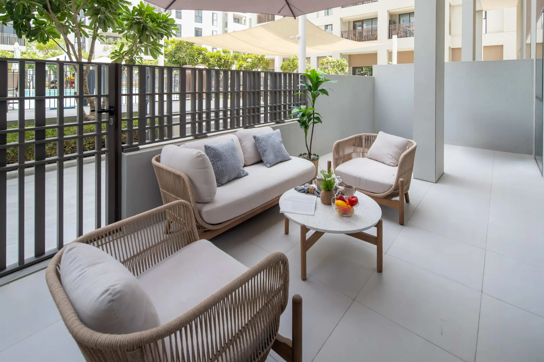 Una zona de estar al aire libre con muebles tejidos y una mesa redonda.