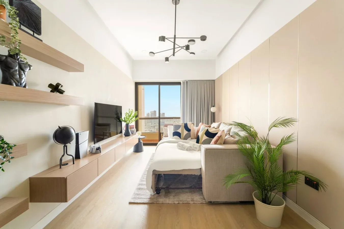 A bright living room with a sofa, television, and large window.